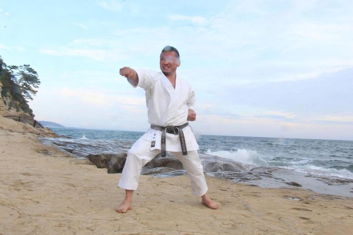 seorang pria berkimono putih berdiri di pantai