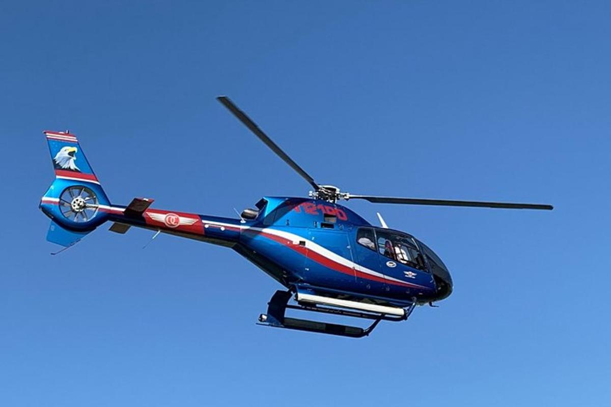 un elicottero blu e rosso che vola nel cielo