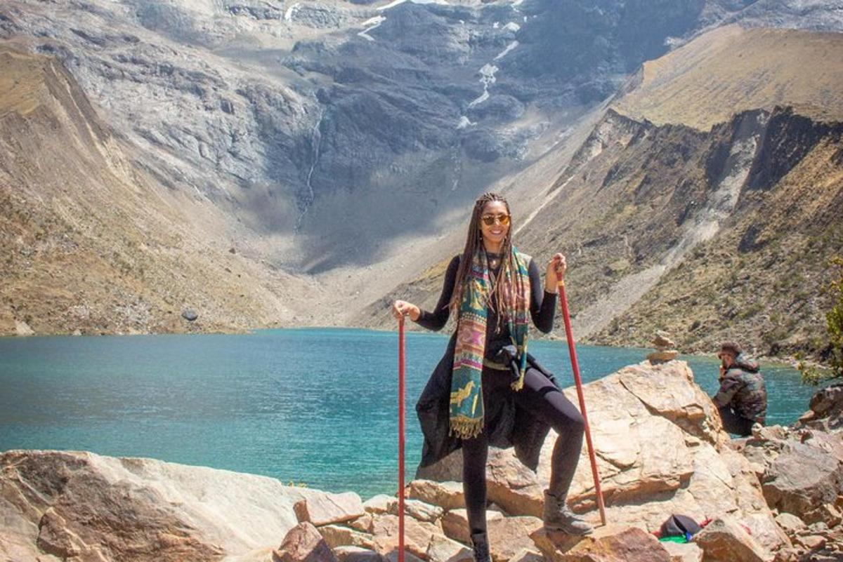 seorang wanita berdiri di atas batu berhampiran tasik