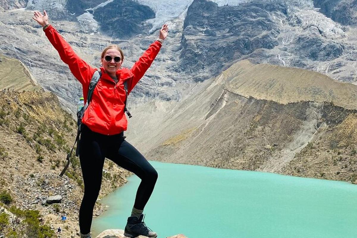 seorang wanita berdiri di atas gunung dengan tangan terangkat
