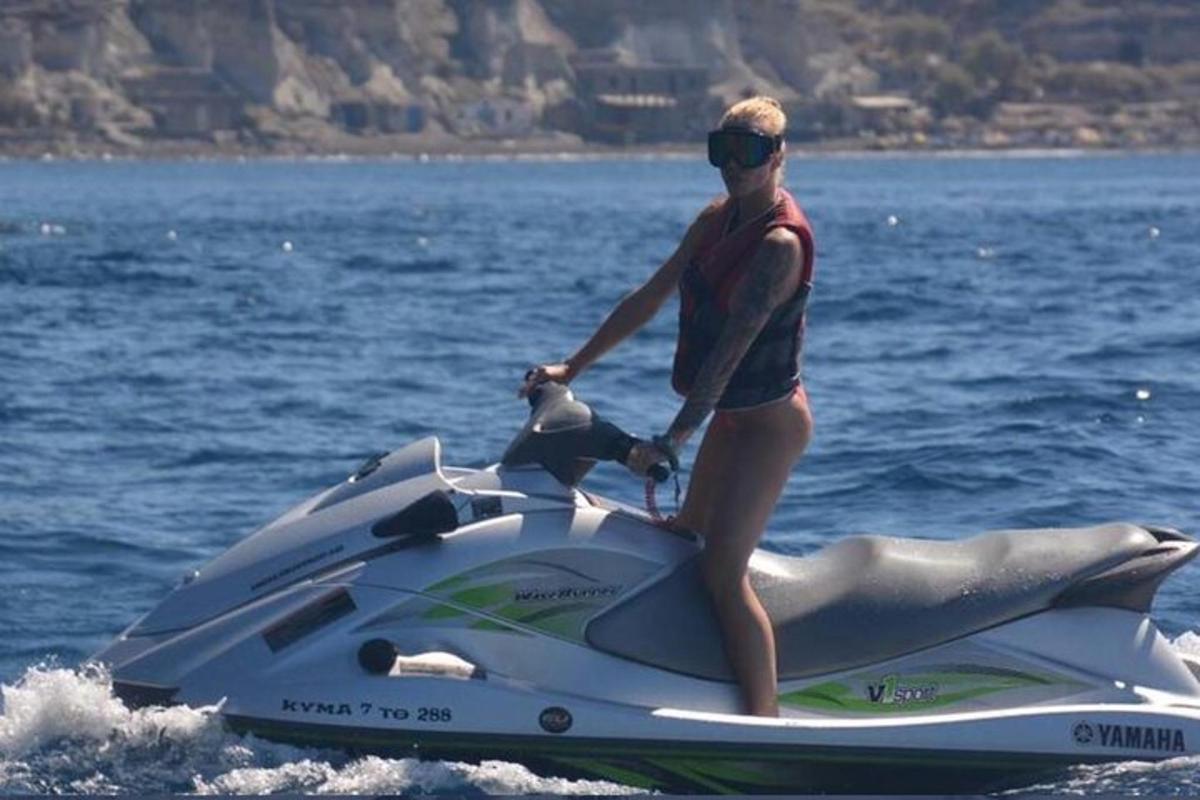 una dona en una moto aquàtica amb un gos en una moto aquàtica