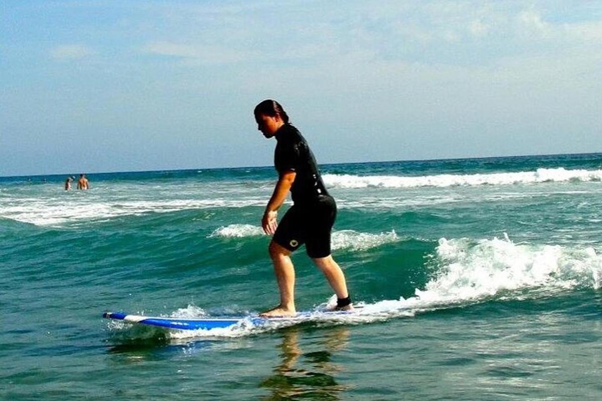 muž jedoucí na vlně na surfovém prkně v oceánu