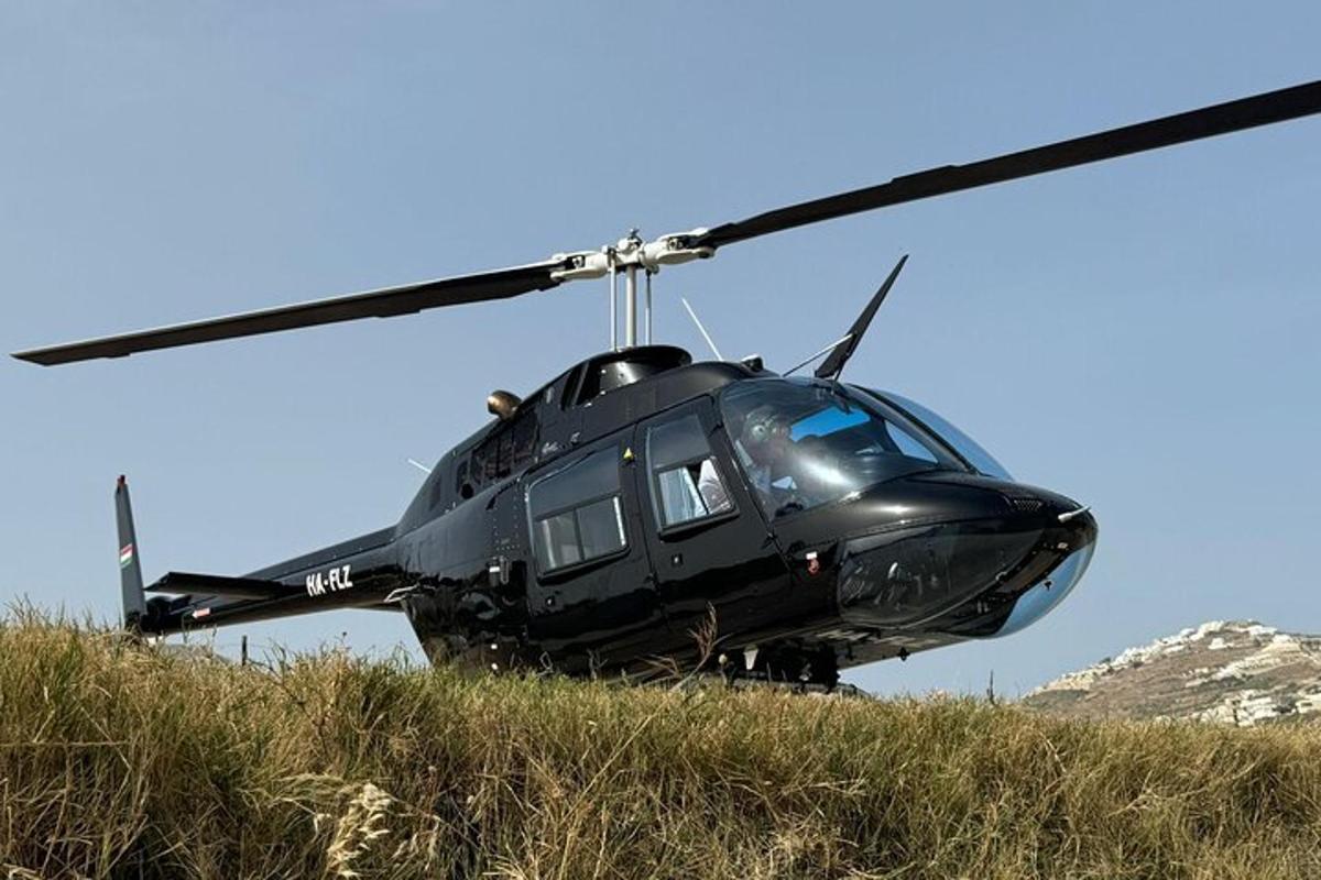 a black helicopter sitting on top of a hill