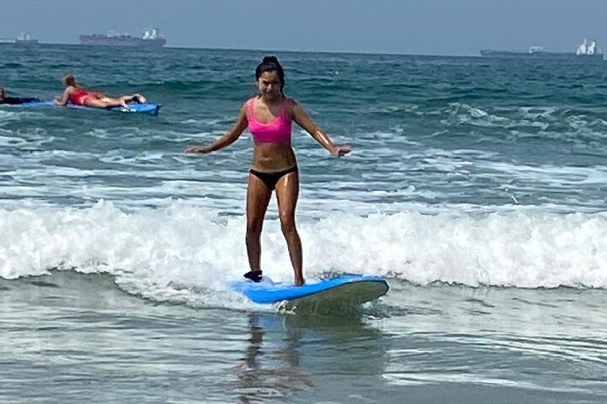 dívka v bikinách jedoucí na surfu v oceánu