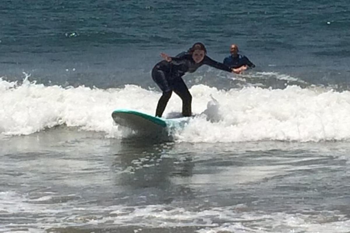 žena jedoucí na vlně na surfovém prkně v oceánu