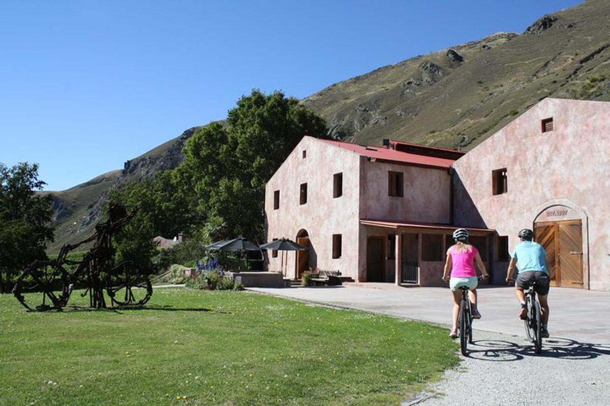 dues persones anant en bicicleta davant d'un edifici