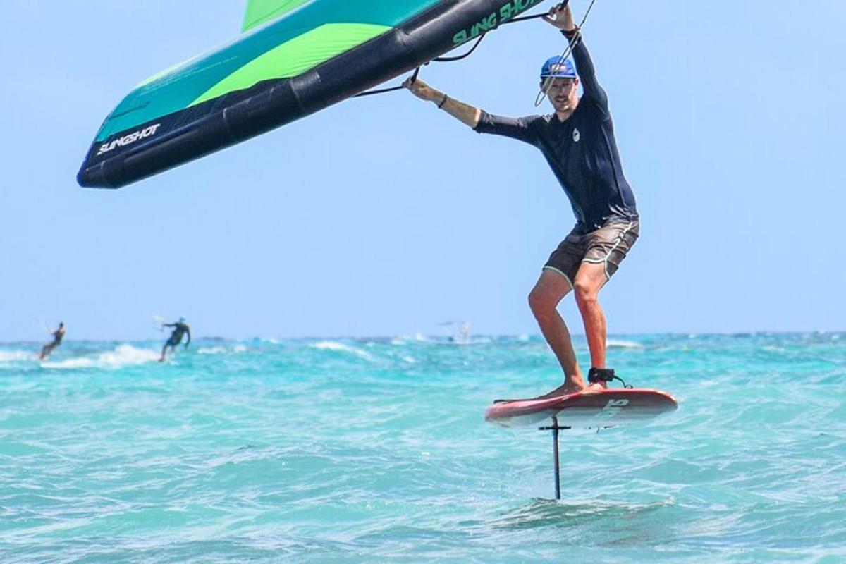 seorang lelaki berdiri di atas papan luncur di lautan