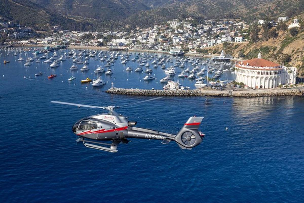 ένα ελικόπτερο που πετάει πάνω από ένα υδάτινο σώμα με βάρκες