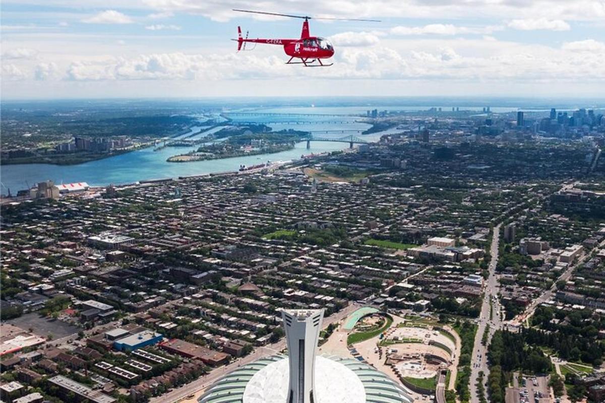 egy piros helikopter repül egy toronnyal rendelkező város felett