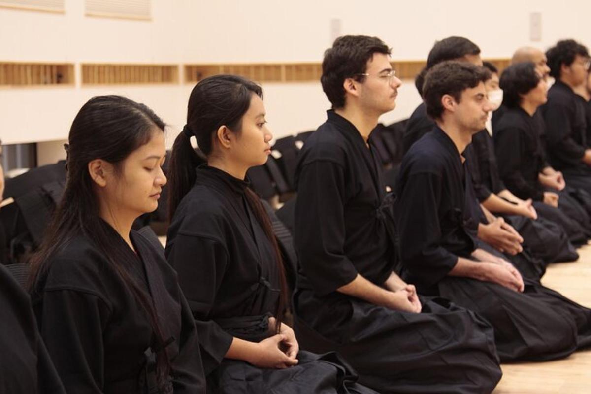 egy csoport fekete köpenyes ember meditálva ül