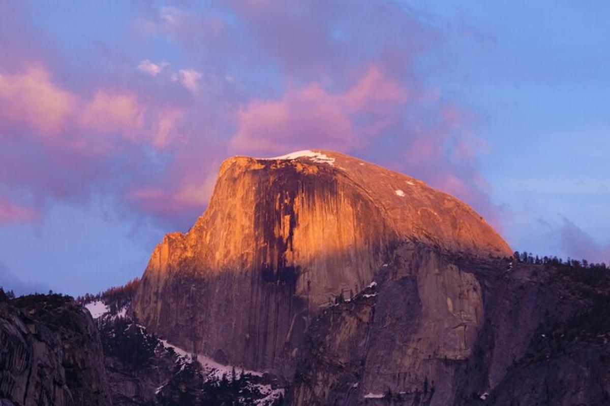 a mountain peak with a cloudy sky in the background