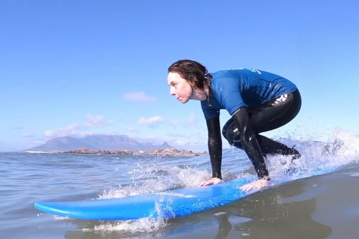 una donna che cavalca una tavola da surf blu in acqua