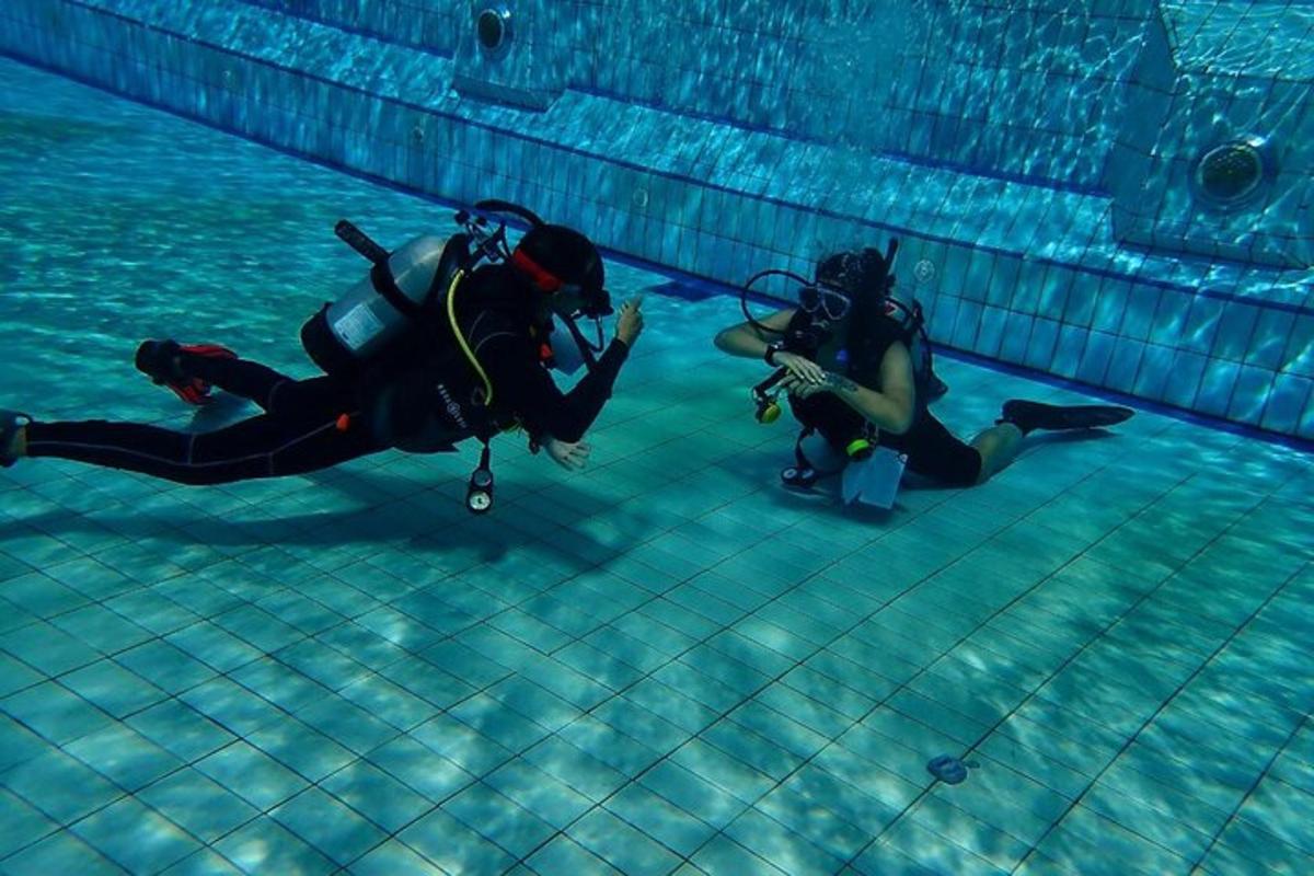 zwei Personen in Taucherausrüstung in einem Schwimmbad