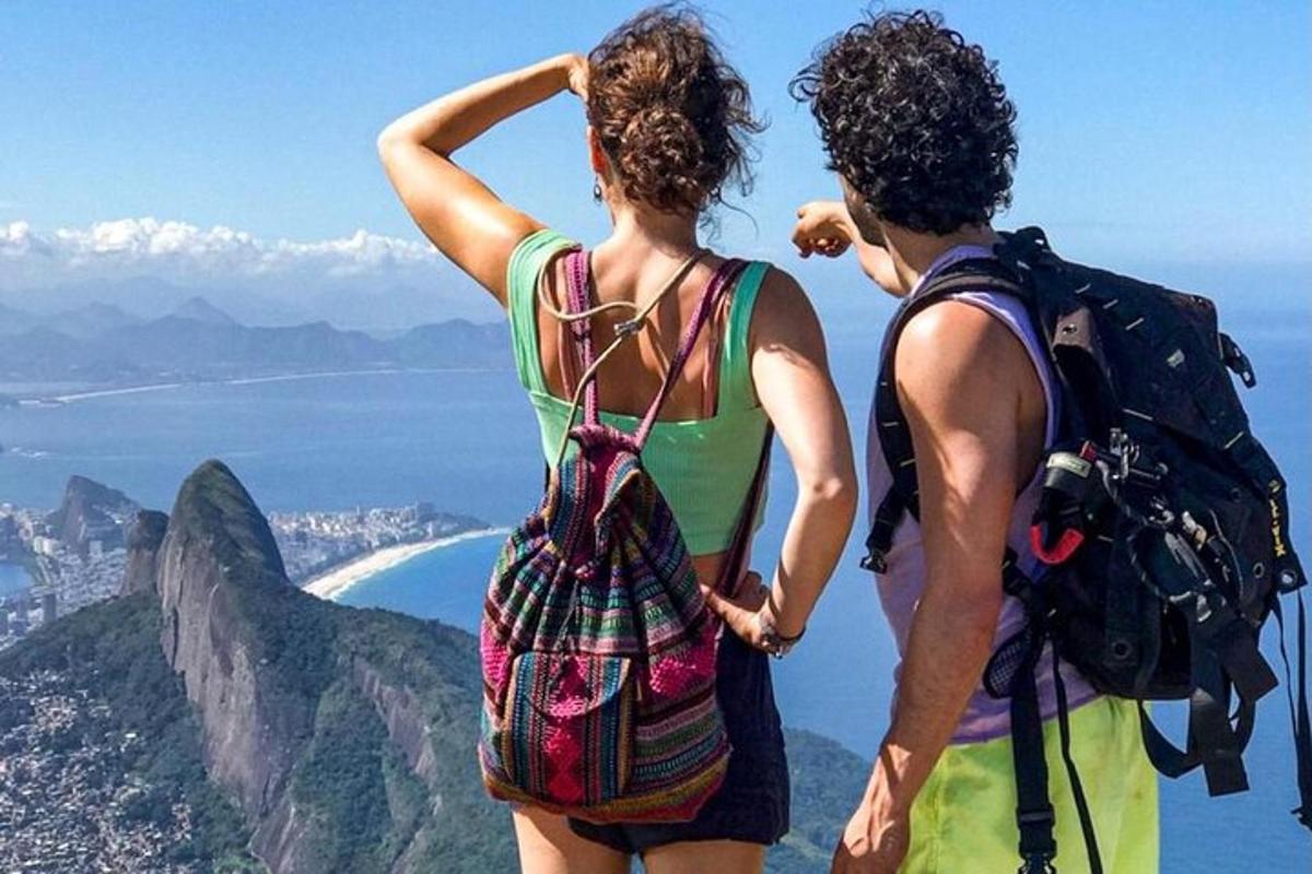 Tveir menn standa á fjallstindi og horfa á útsýnið