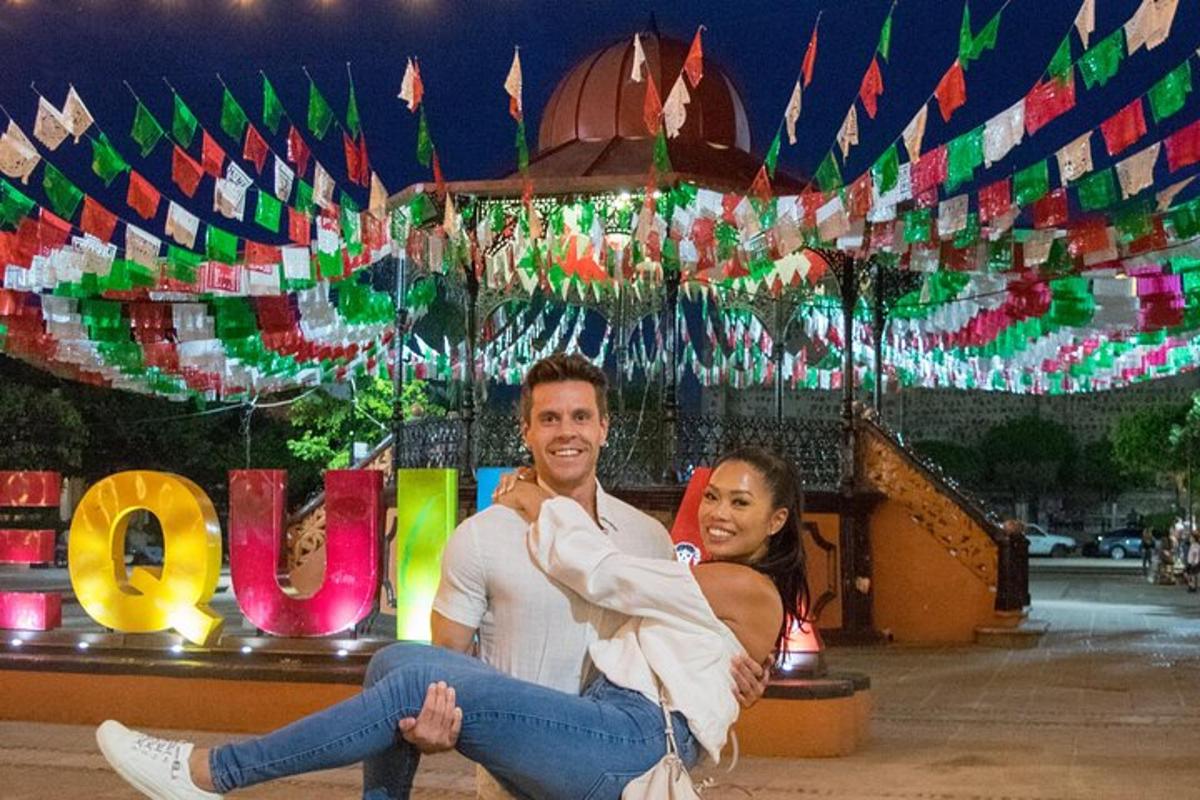 a man and woman sitting in front of a carousel