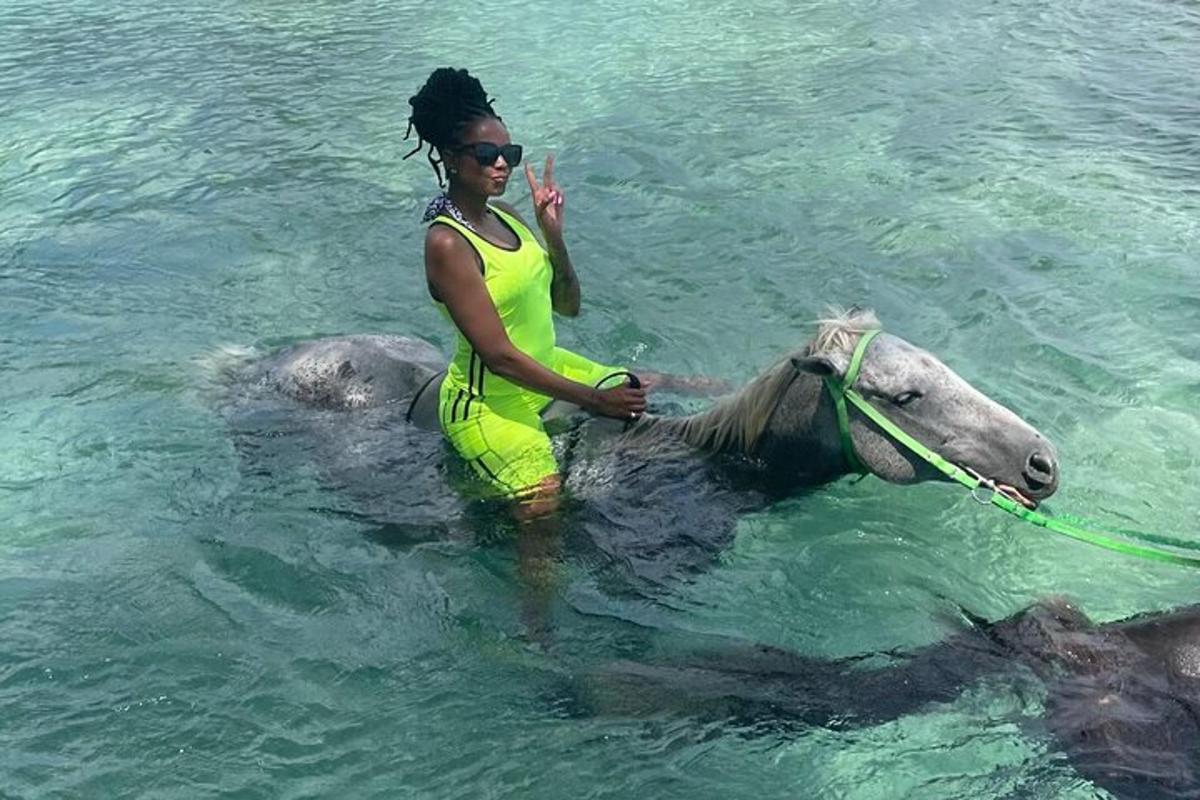 uma mulher sentada em um cavalo na água