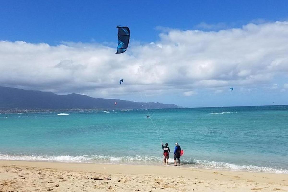 dvoje ljudi puštaju zmaja na plaži