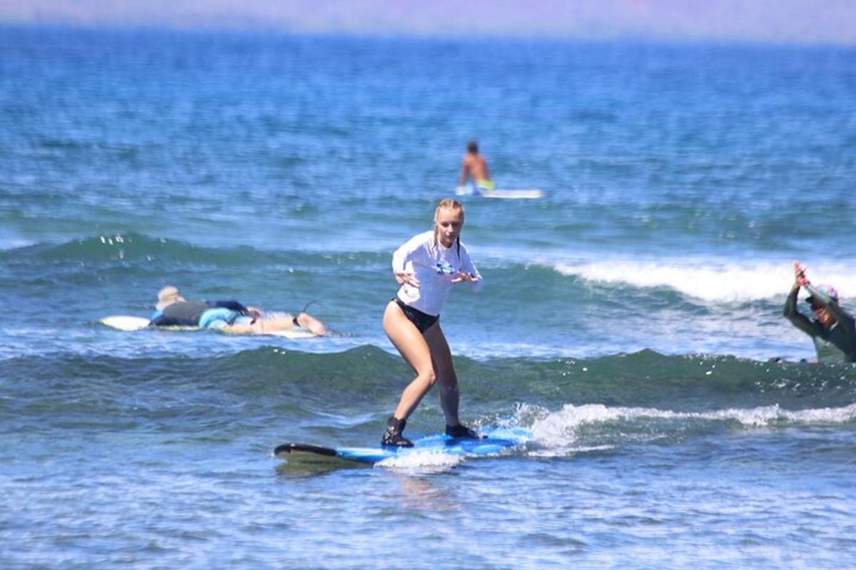 una donna che cavalca un'onda su una tavola da surf nell'oceano