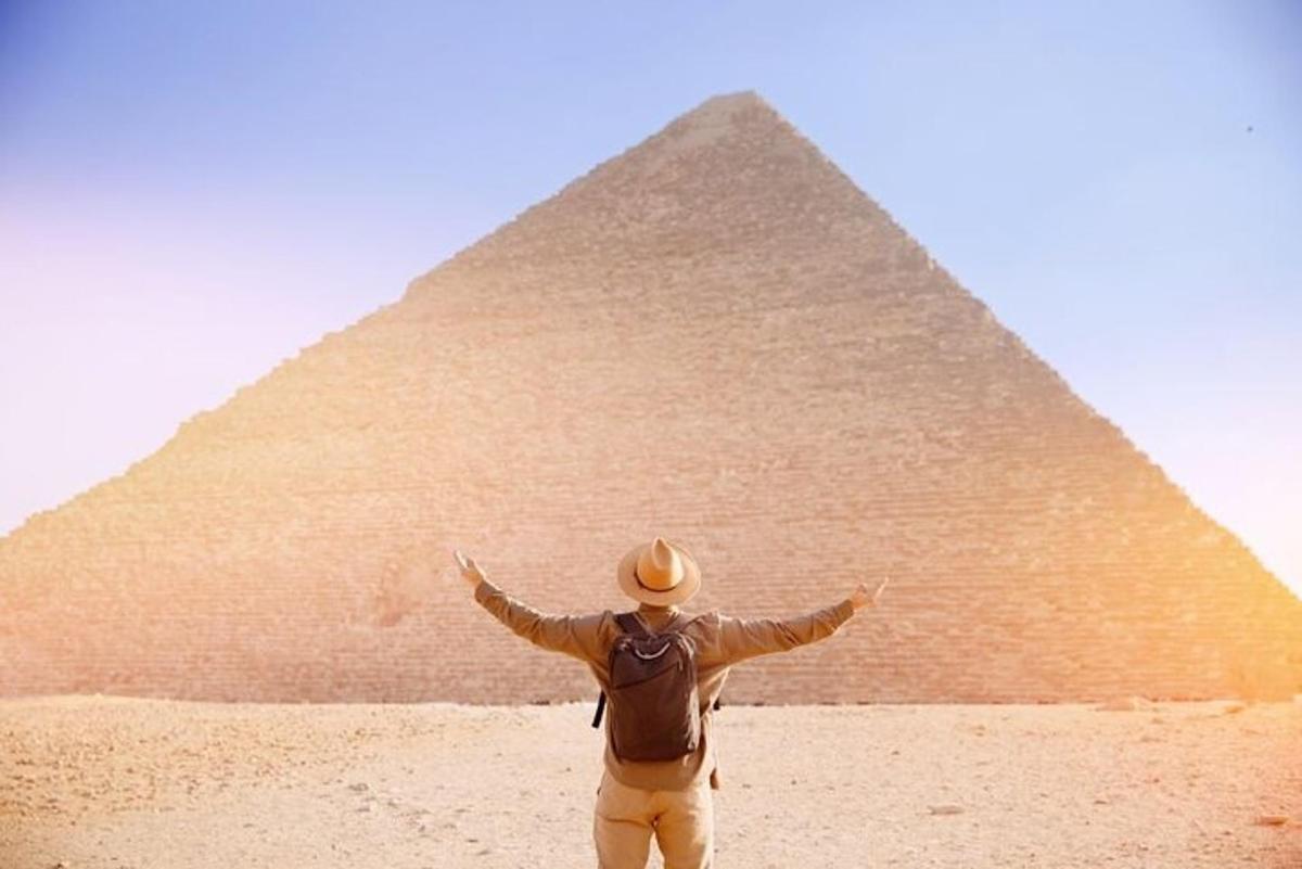 un bărbat care stă în fața unei piramide