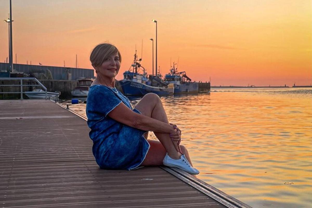 žena sedící na molu u vody
