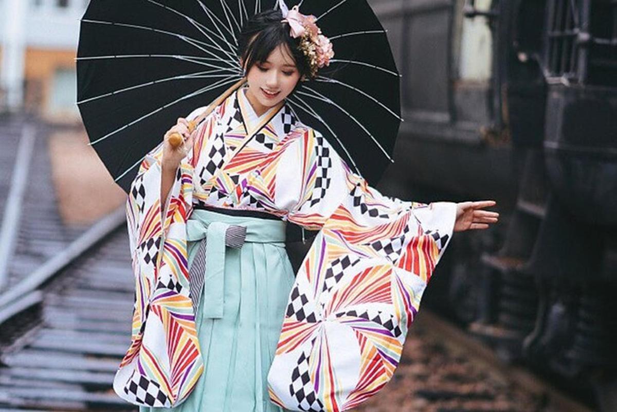 una donna in kimono che tiene in mano un ombrello