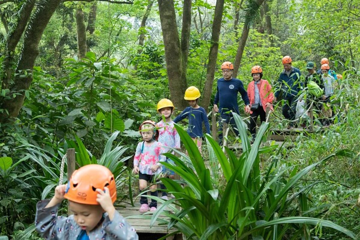 a group of people wearing hard hats in the forest