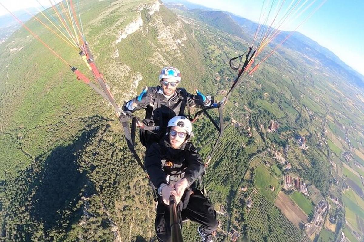 Dos personas están montando en paracaídas en una montaña.
