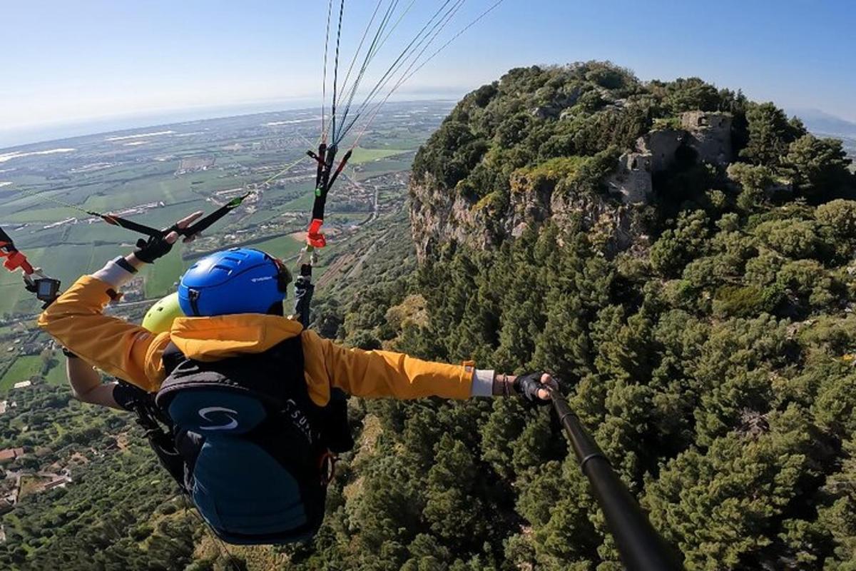 Un hombre volando por el aire mientras monta un paracaídas.