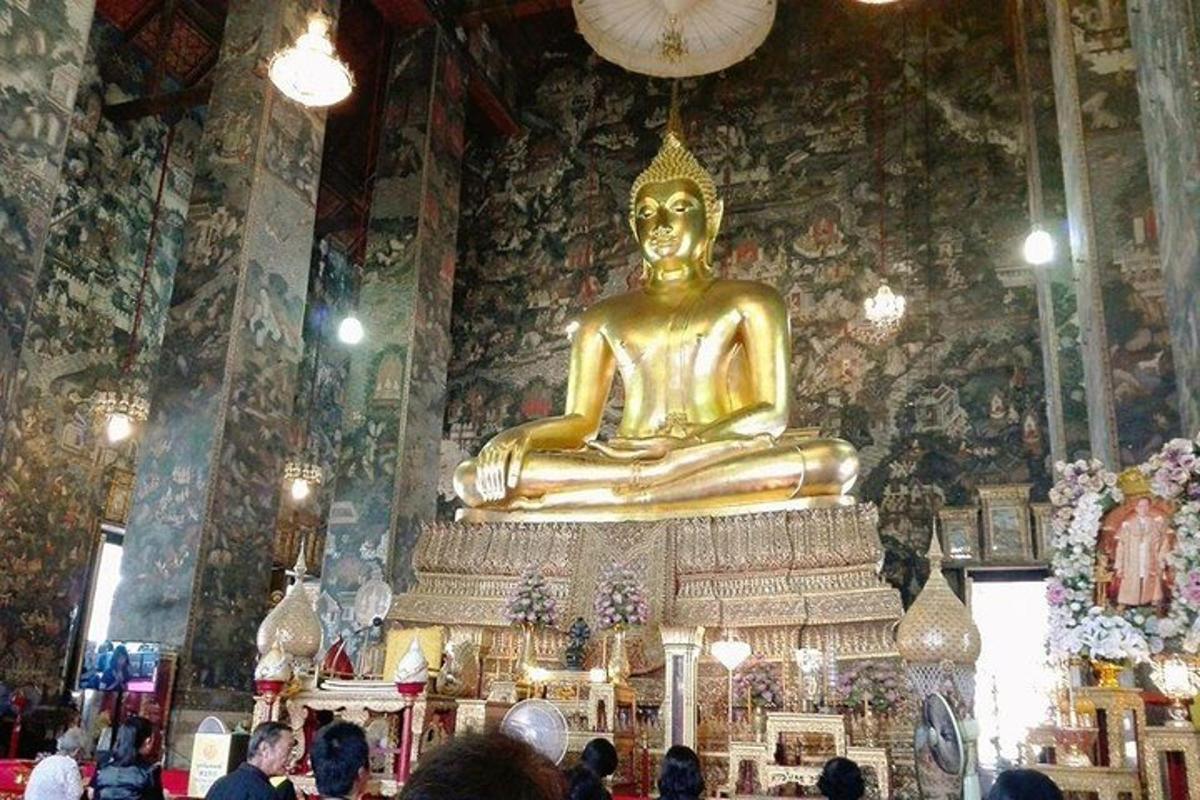 un grup de persones dempeus en un temple amb una gran estàtua d'or