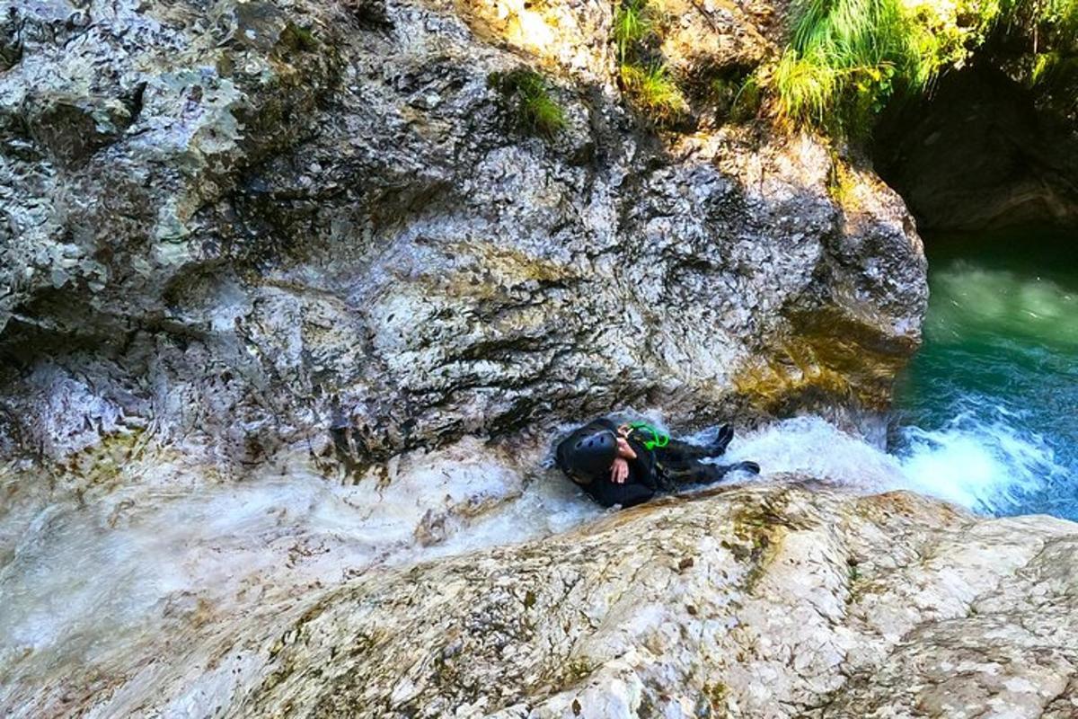 una persona sdraiata su una roccia vicino a un fiume