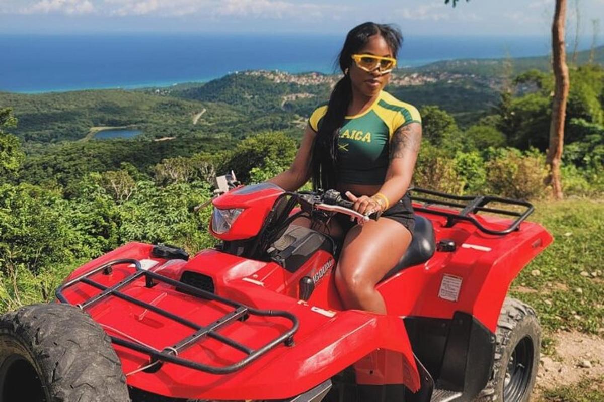 a woman sitting on a red atv on a mountain