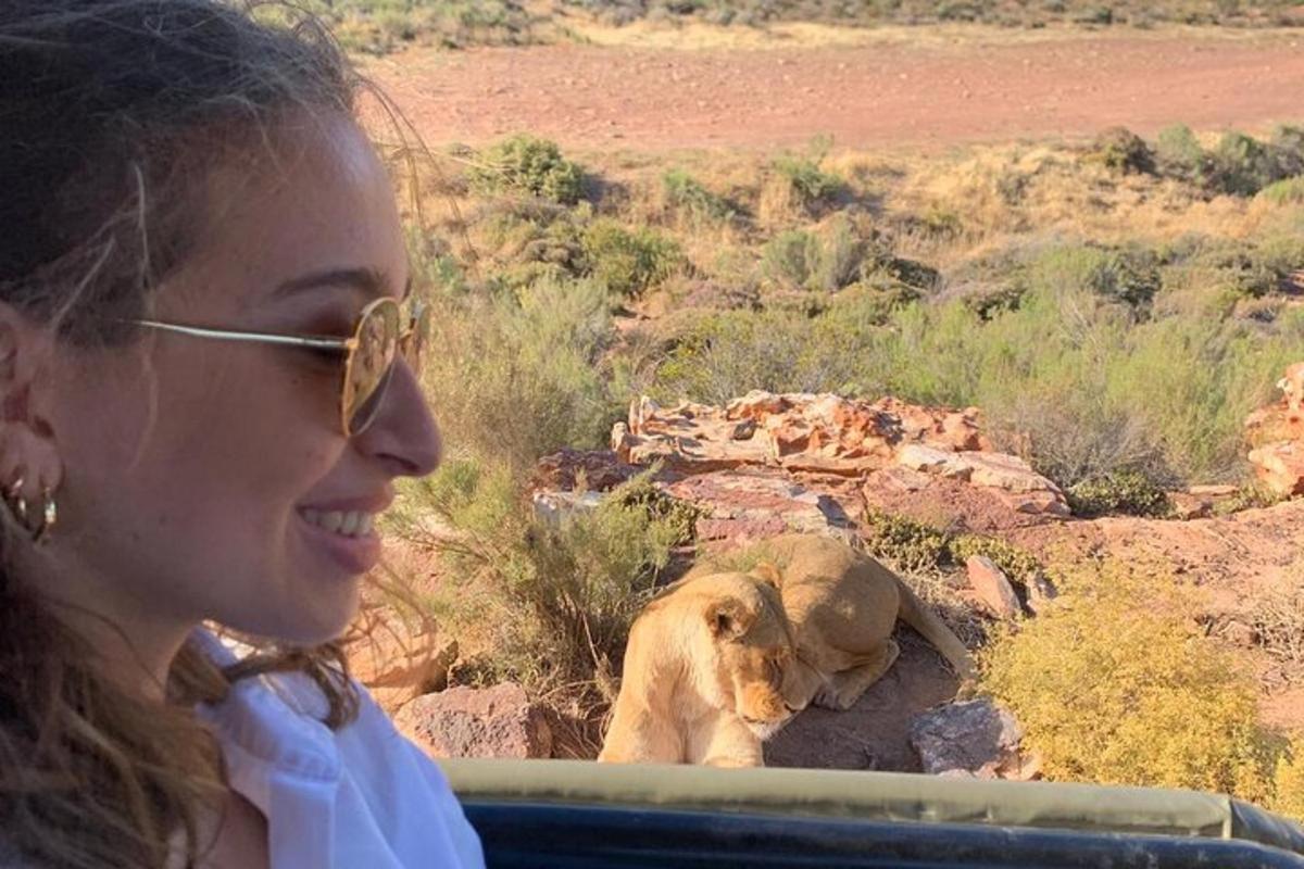 una donna sorride mentre guarda un leone