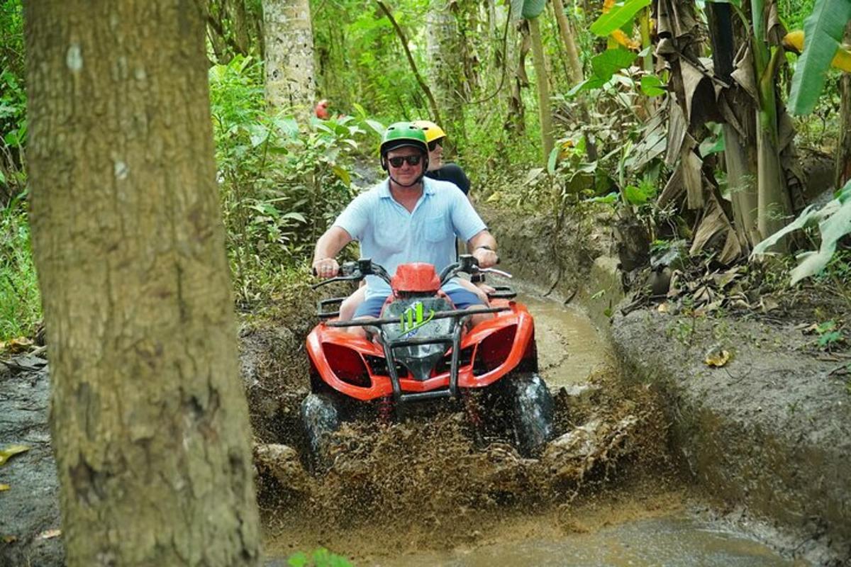 un uomo che guida un quad nel fango