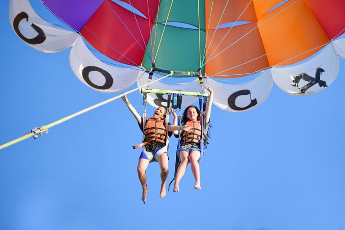 two people are riding on a parachute