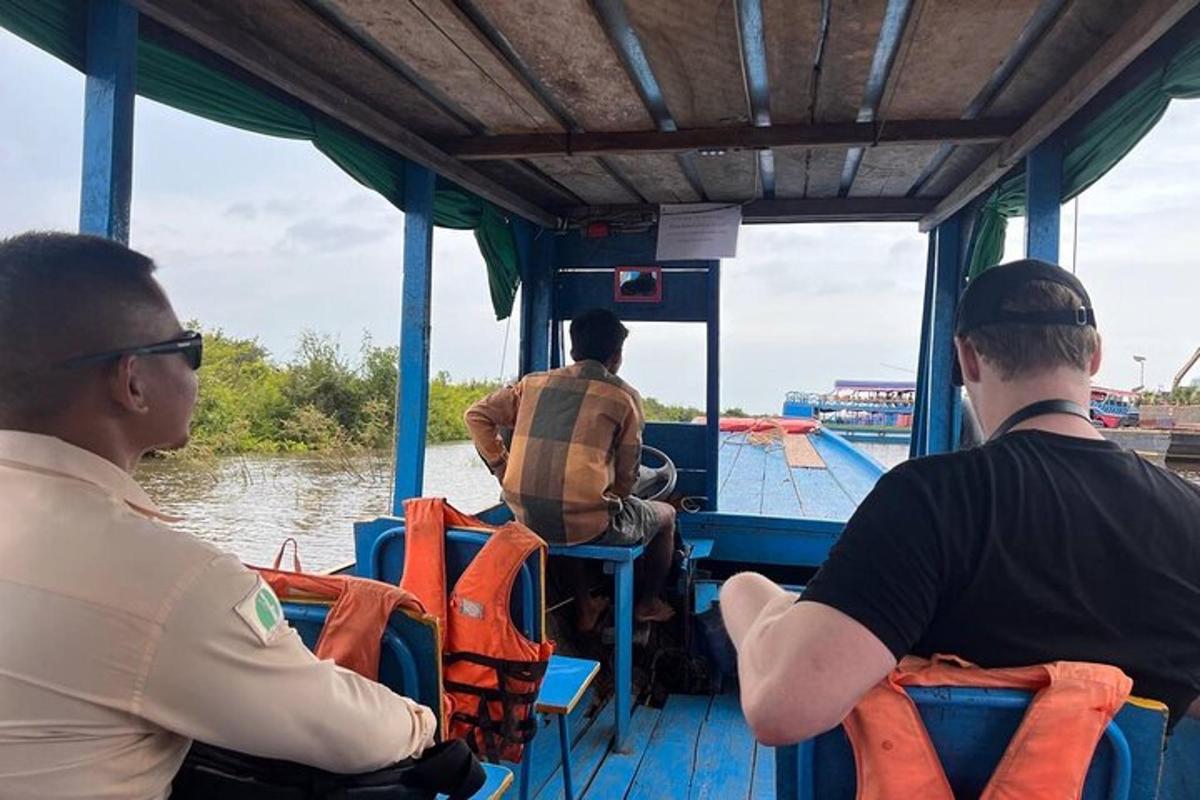 một nhóm đàn ông ngồi trên thuyền trên mặt nước