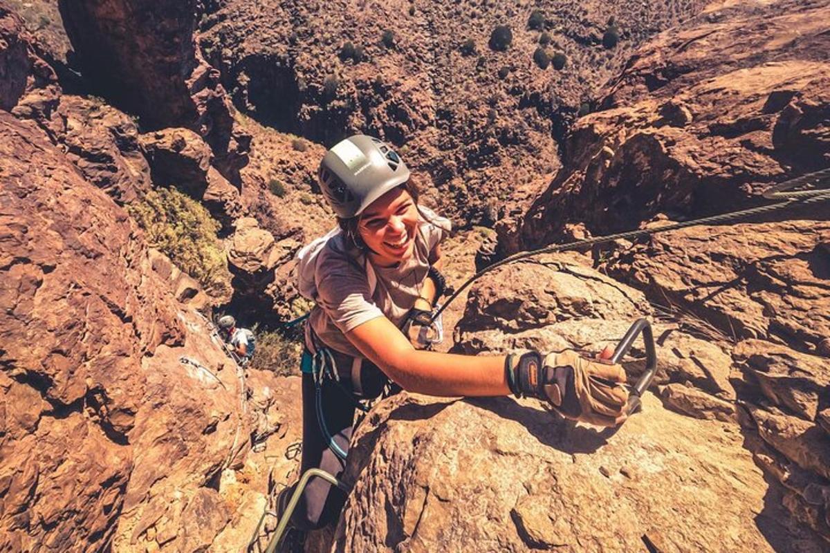 seorang wanita sedang mendaki gunung berbatu