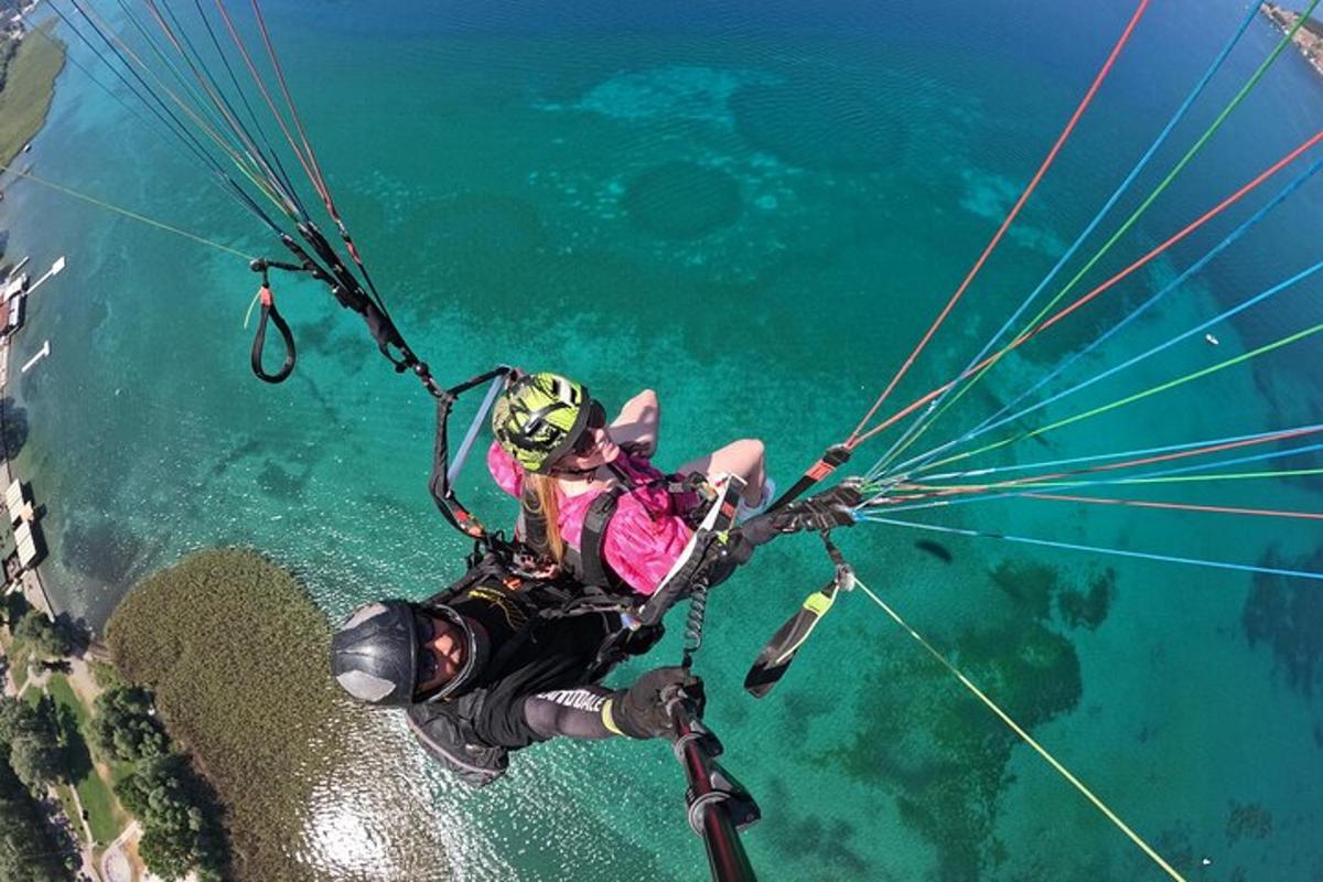 a person hanging from a parachute over the water