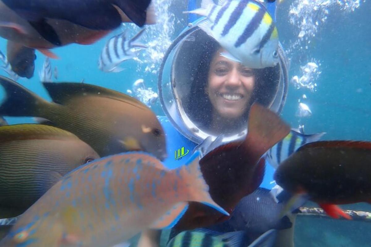un uomo in acqua che guarda alcuni pesci