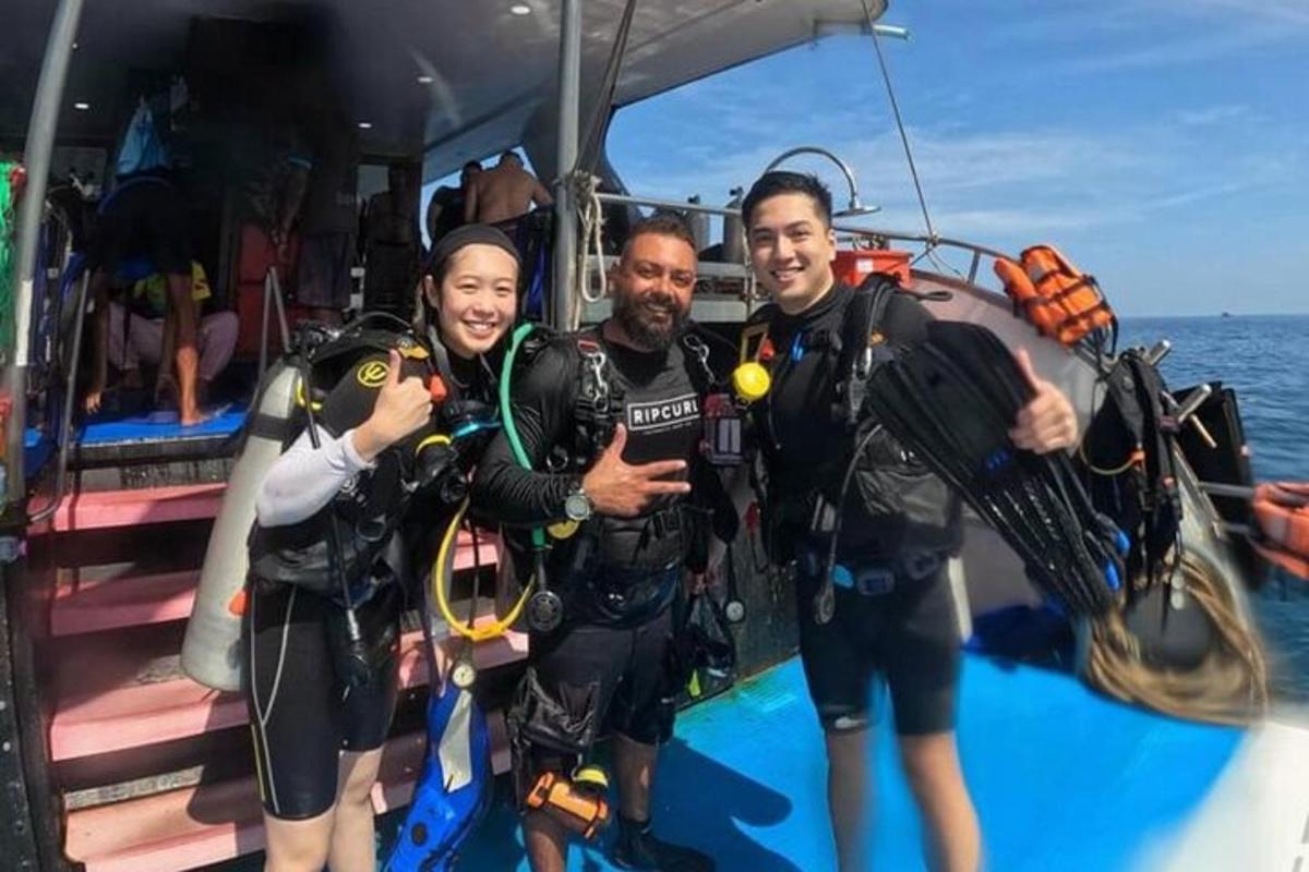 un gruppo di tre persone in attrezzatura subacquea su una barca