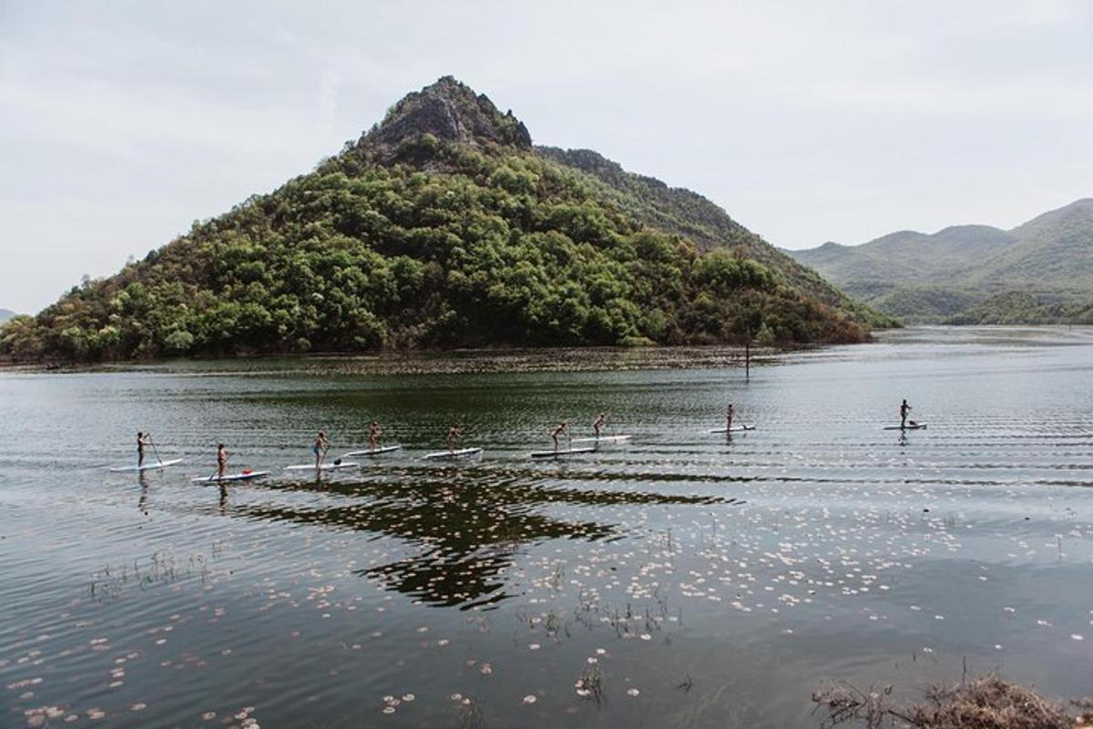um grupo de pessoas na água com uma montanha