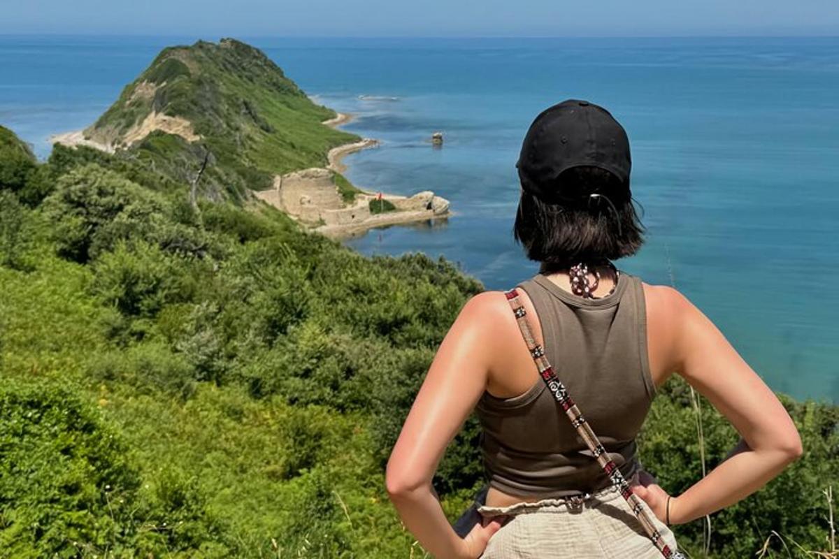 žena stojící na kopci a dívající se na oceán