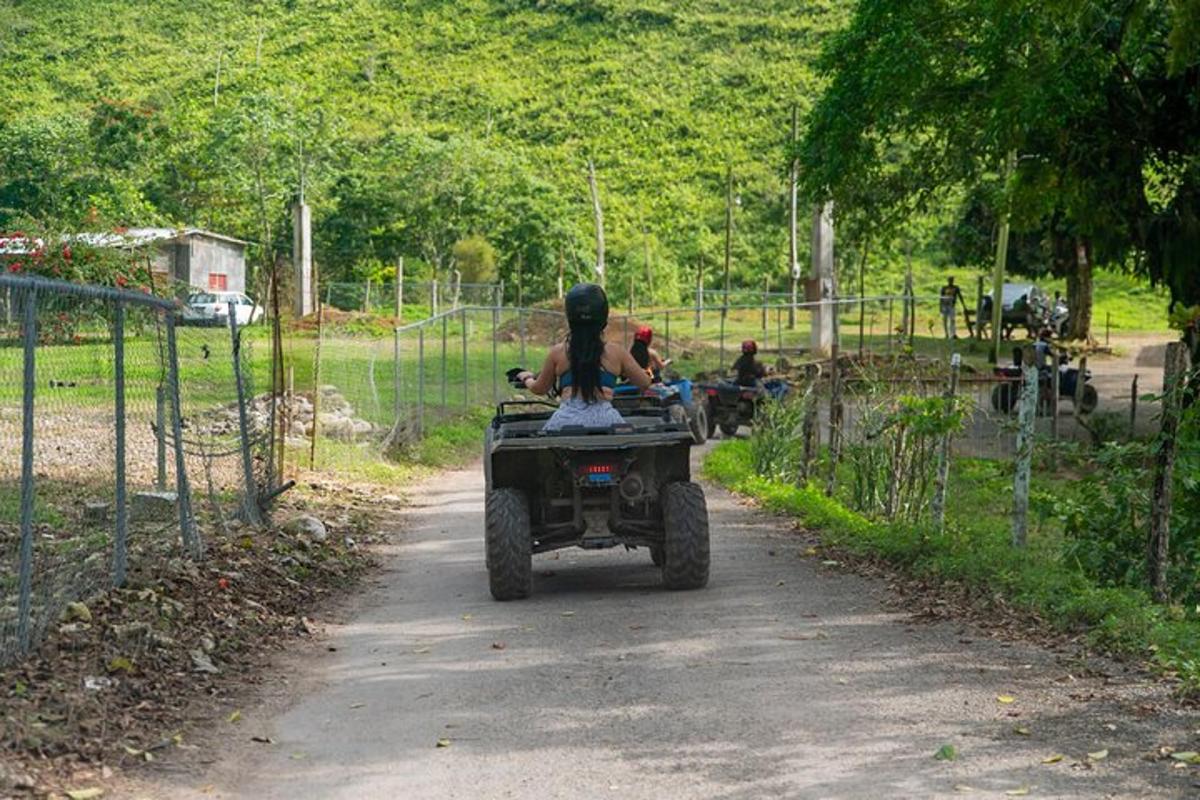 một người đang lái xe bốn bánh trên đường đất