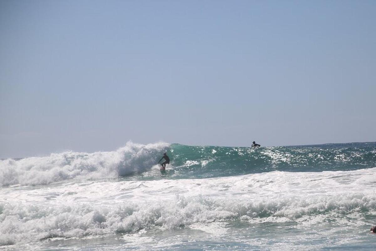 Dva surferja jahata valove v oceanu