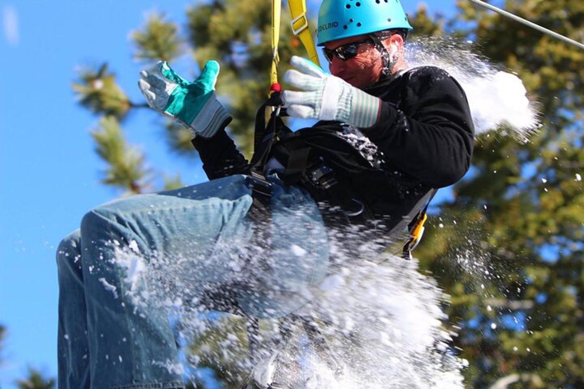 a man flying through the air while holding onto a parachute