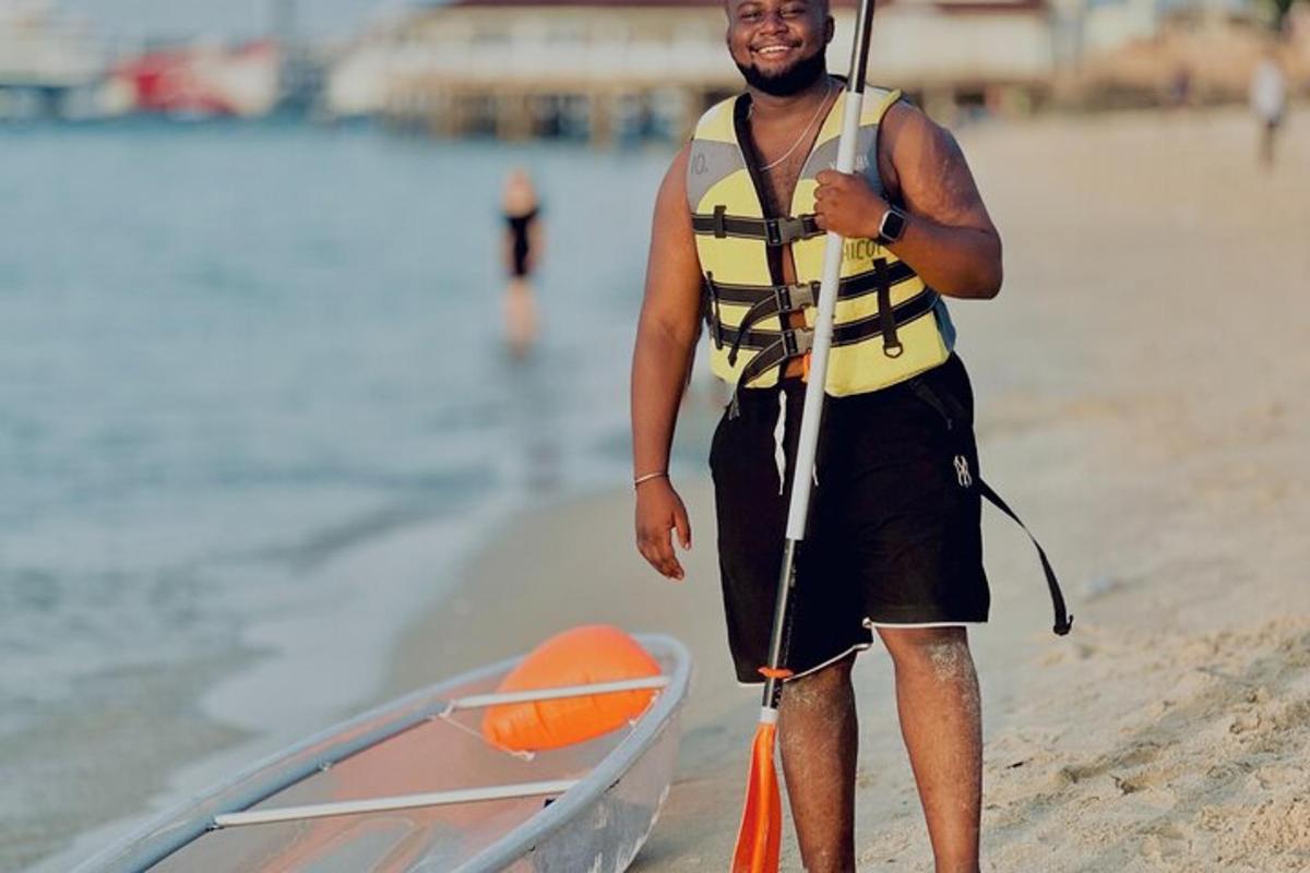 Un hombre está parado en la playa con un remo.