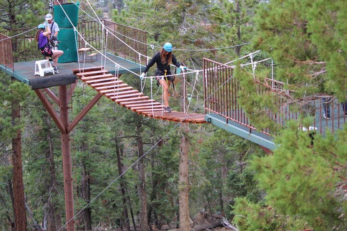 a group of people walking across a suspension bridge