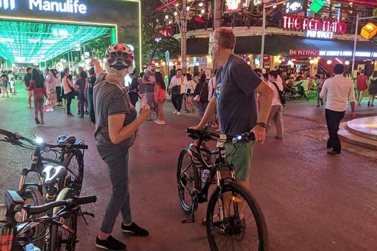 a woman standing next to a man with a bike