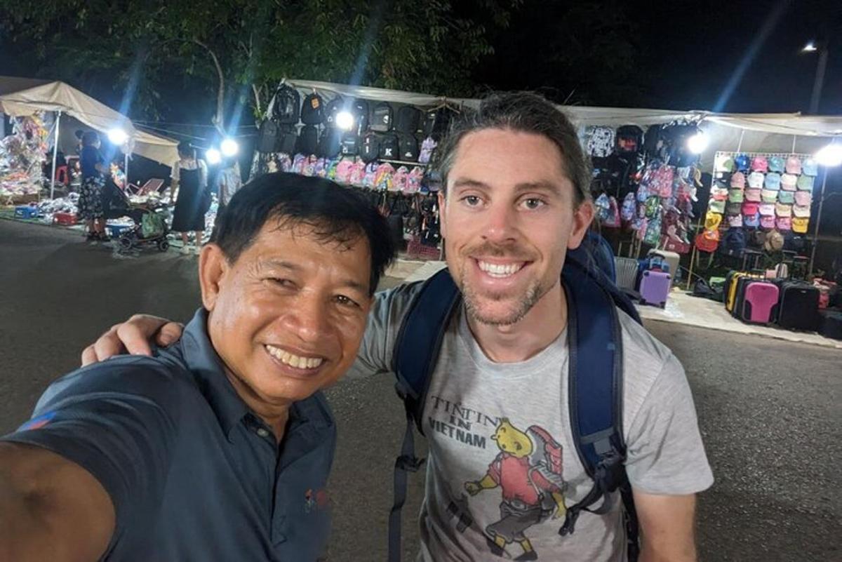 two men posing for a picture in front of a store
