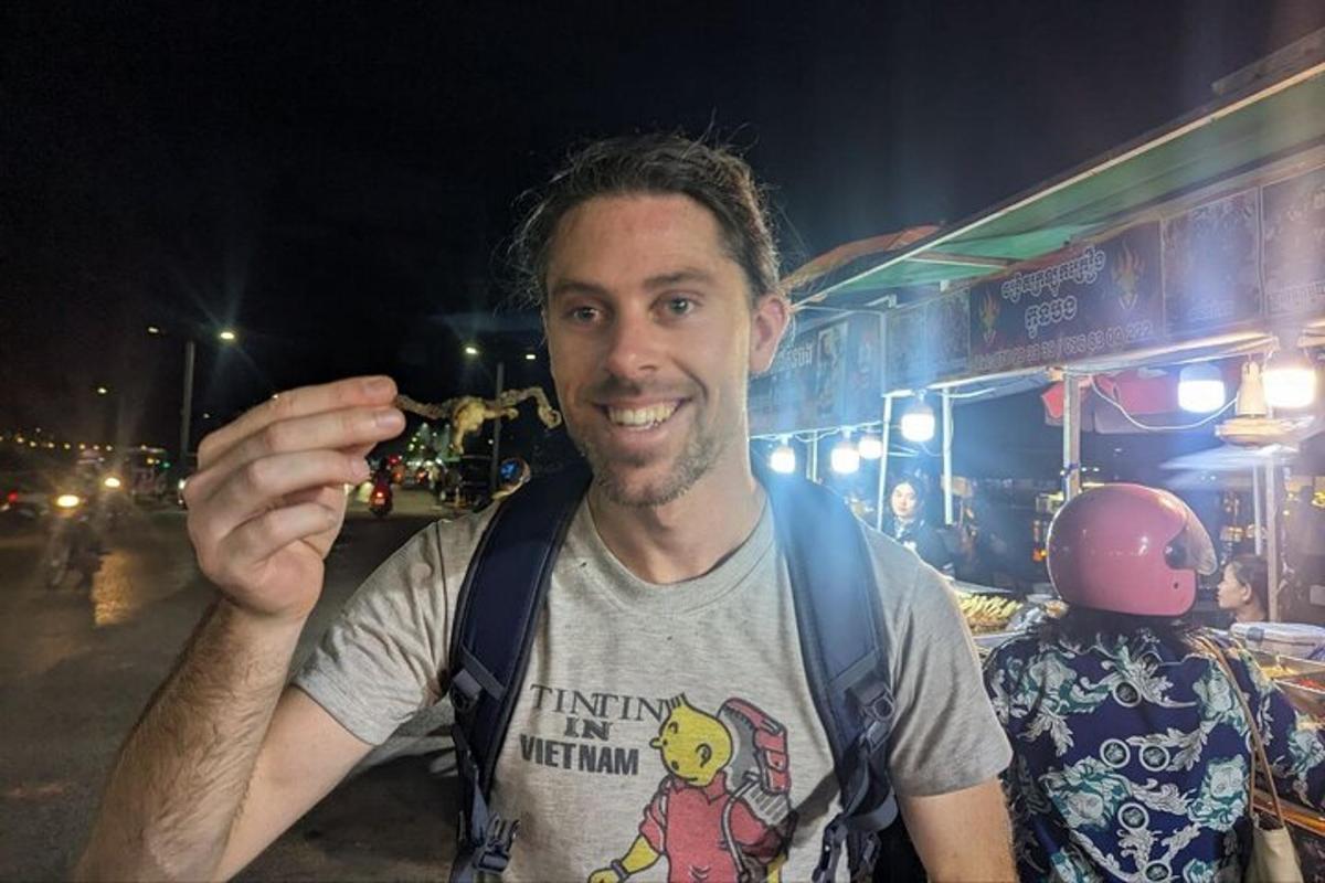 un uomo che tiene in mano una macchina fotografica davanti