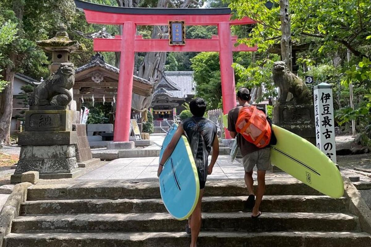 two people walking up some stairs with surfboards